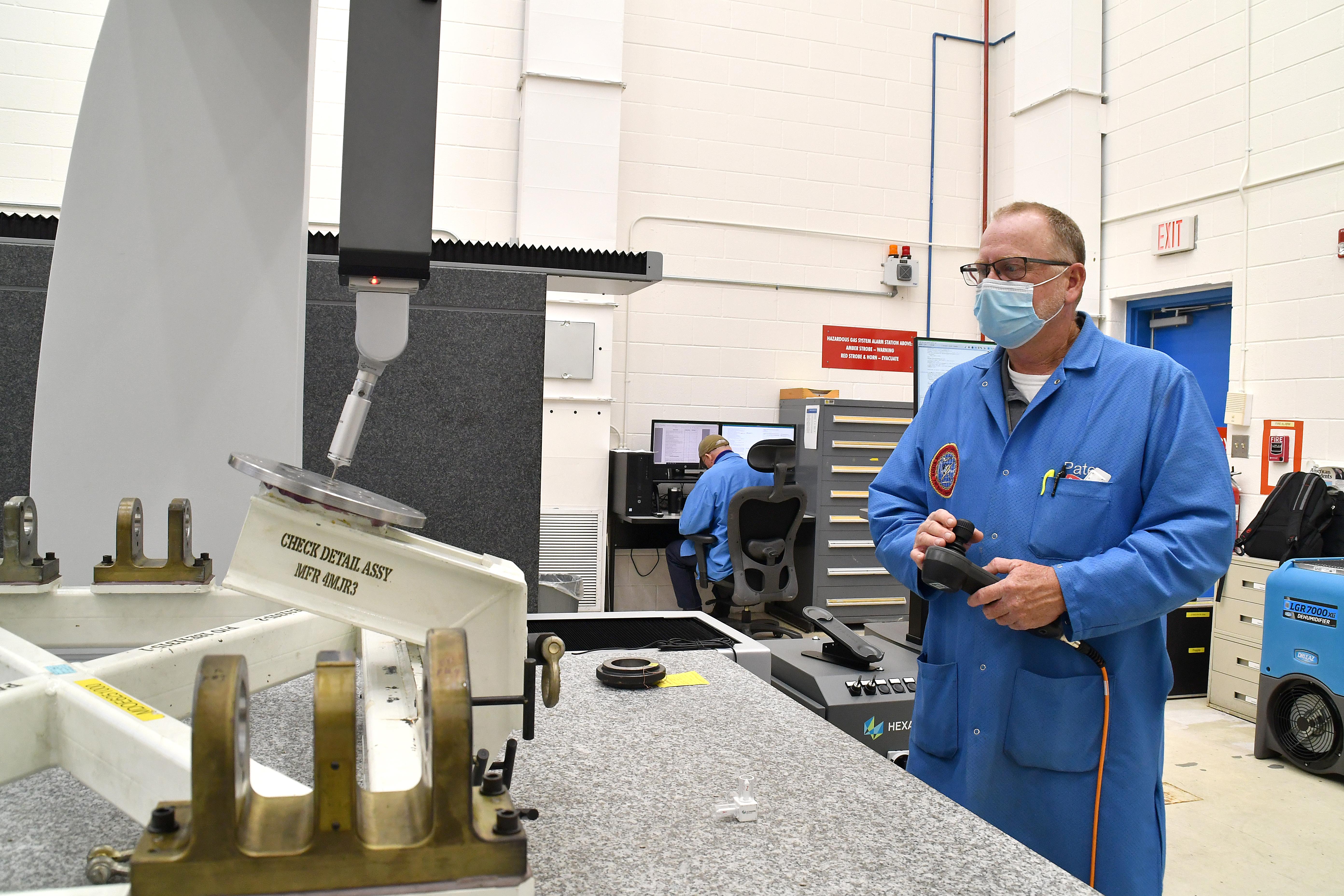 Ben Pate, operations manager at Fleet Readiness Center East’s (FRCE) Precision Measurement Center, operates a coordinate measuring machine (CMM). A CMM is a device that measures the geometry of physical objects by sensing points on the surface of the object with a probe. 