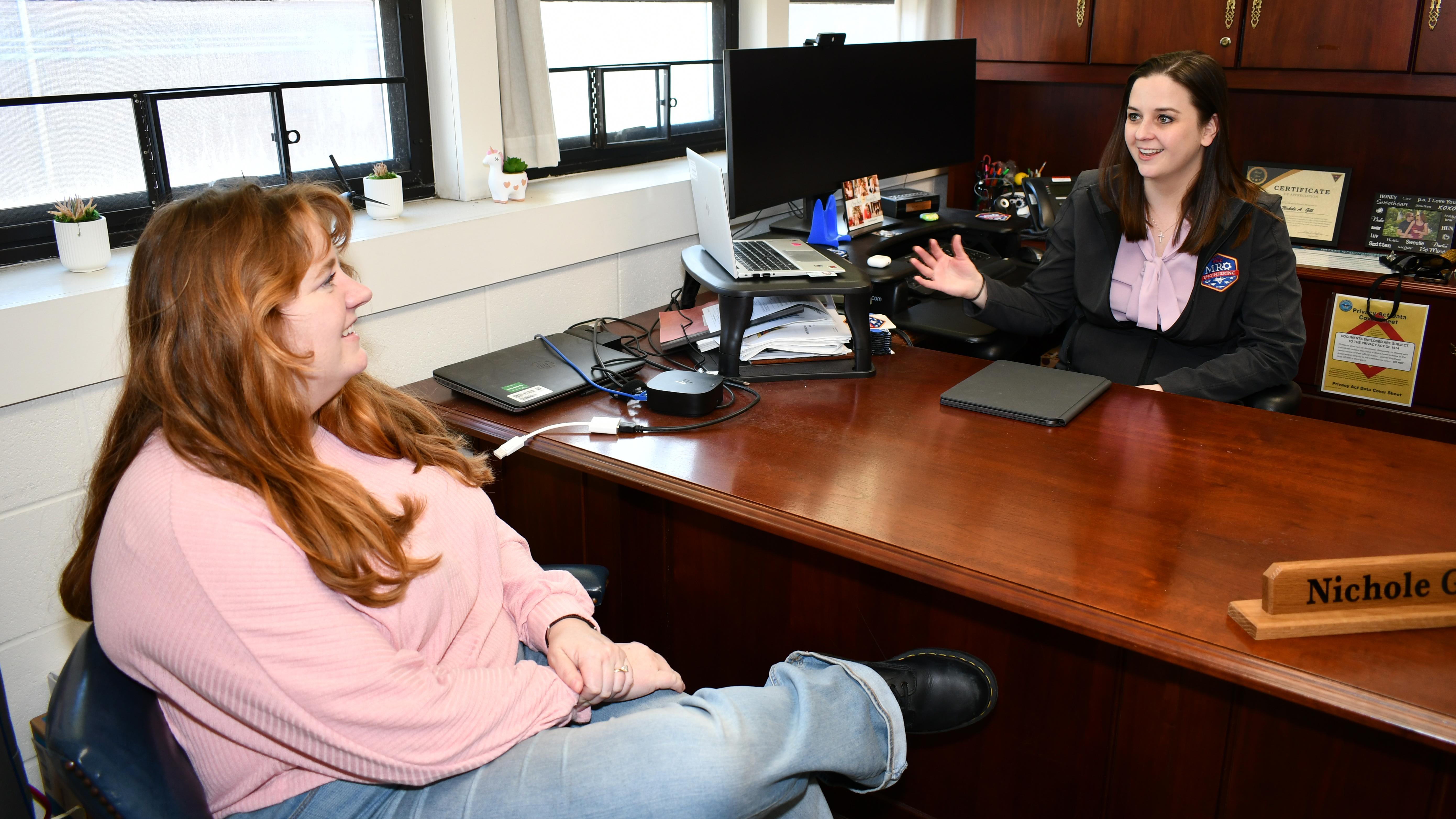 FRC East mentor of the year and her mentee hold discussion at desk