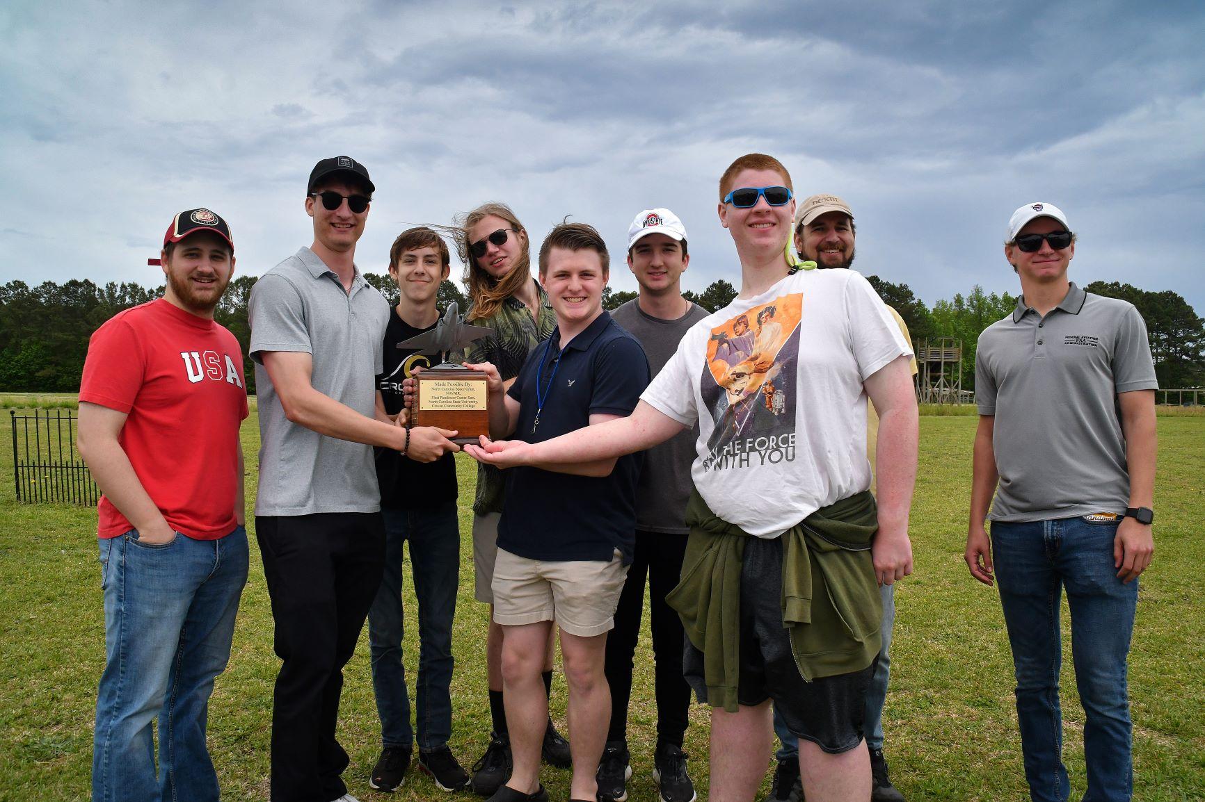Fleet Readiness Center East (FRCE) engineers Davis Harrison, far left, and Josh Rusmisel, far right, pose with students and faculty from Croatan High School who took first place in the 2023 Ultimate Unmanned Aerial Vehicle Competition, held April 22 in Newport. Students representing eastern North Carolina high schools designed unmanned aerial vehicles for the competition, which evaluated the speed and maneuverability of their creations. 
