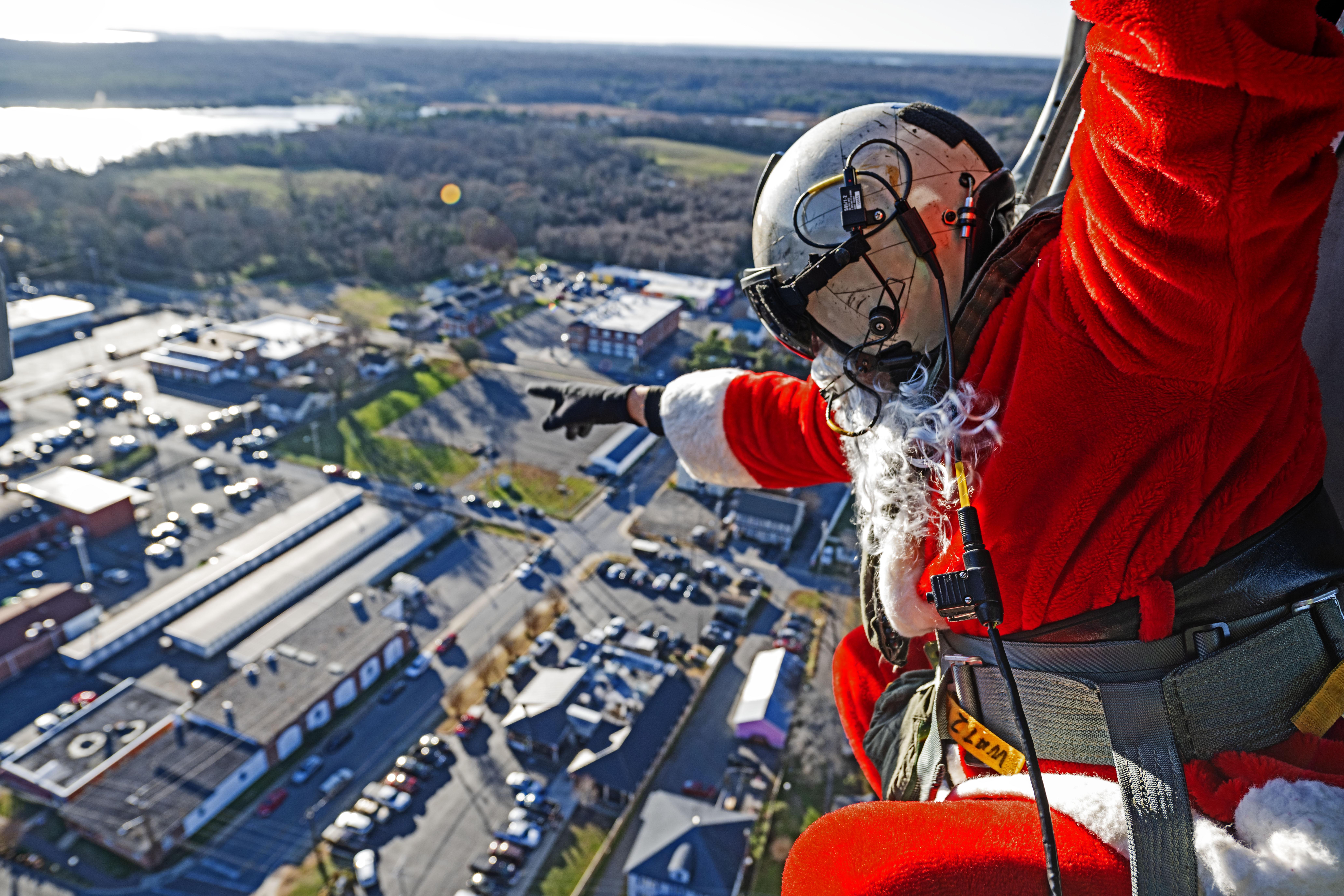 Santa waves to residents below from the skies of Southern Maryland aboard an in-flight MH-60S Seahawk helicopter.