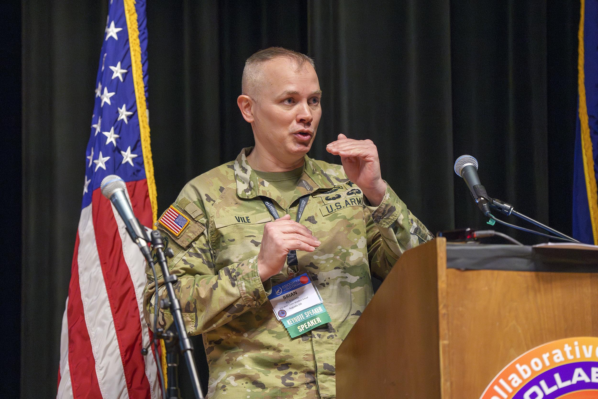 Brig. Gen. Brian Vile, Commandant, United States Army Cyber Warfare School, delivers a keynote address during the Collaborative EW Symposium on March 13 in Point Mugu, California. (U.S. Navy photo by Rob Grabendike)