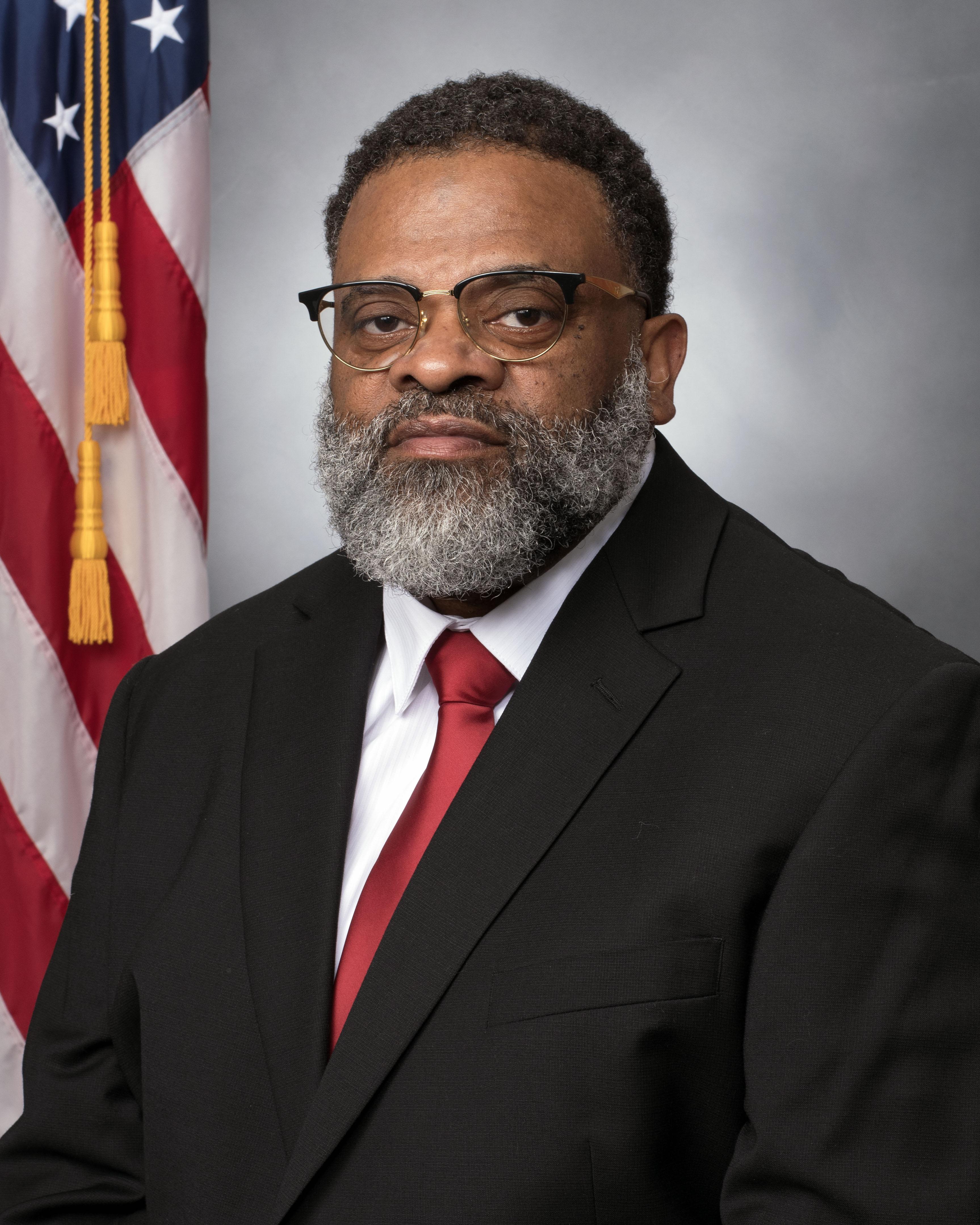 Studio portrait of man in suit in front of American flag