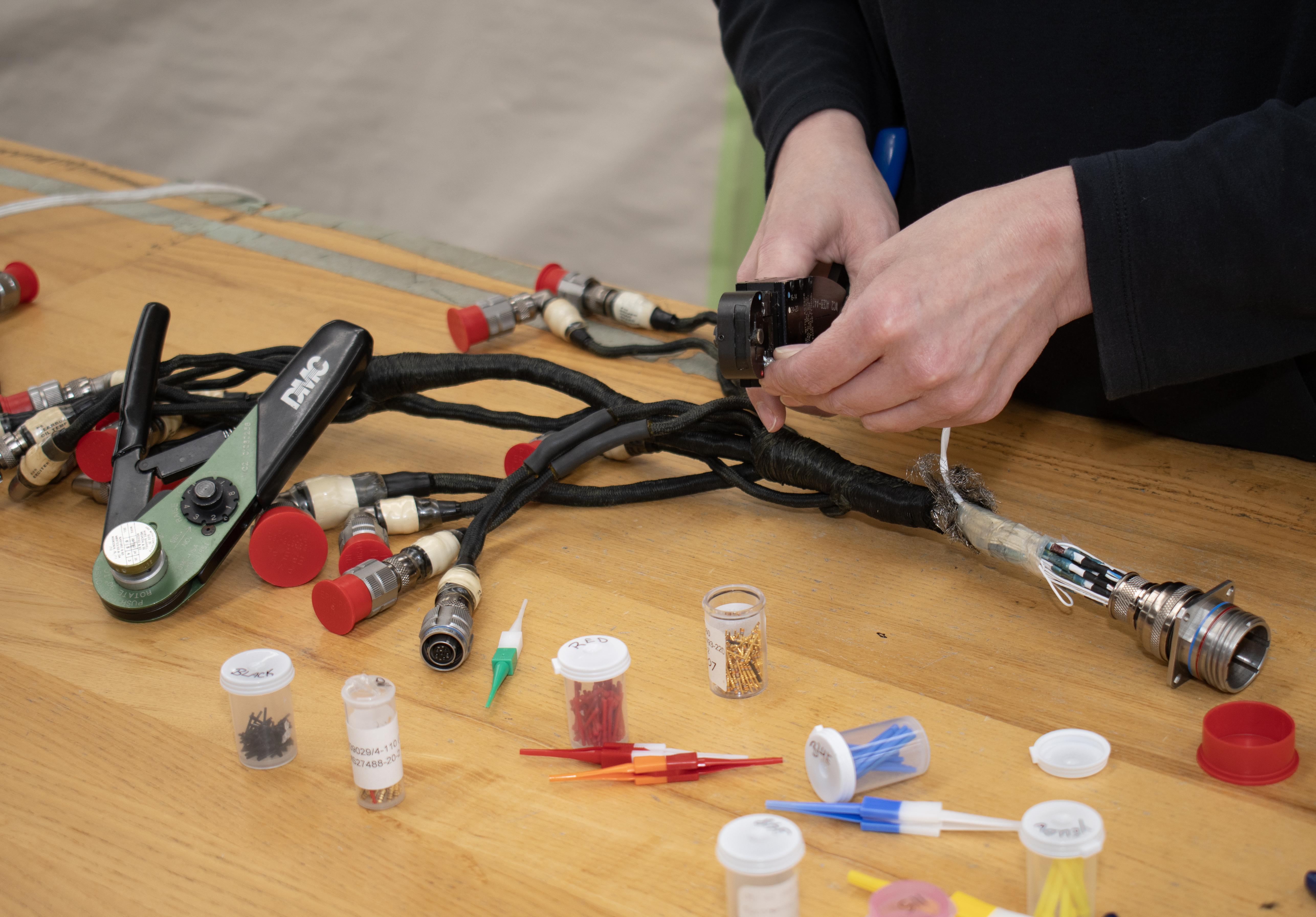 Person's hands working on a wiring harness
