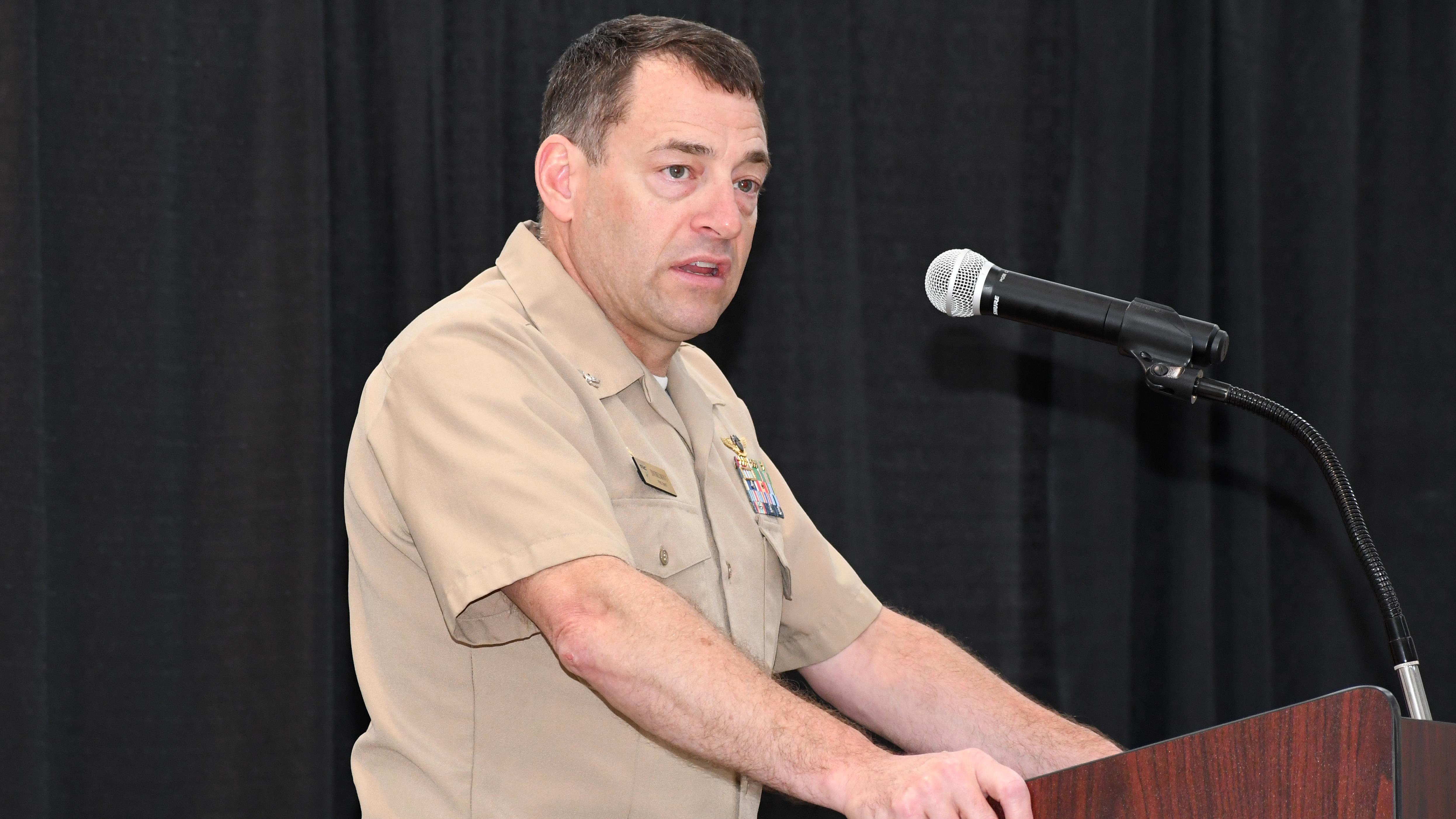 Man speaks from behind lectern