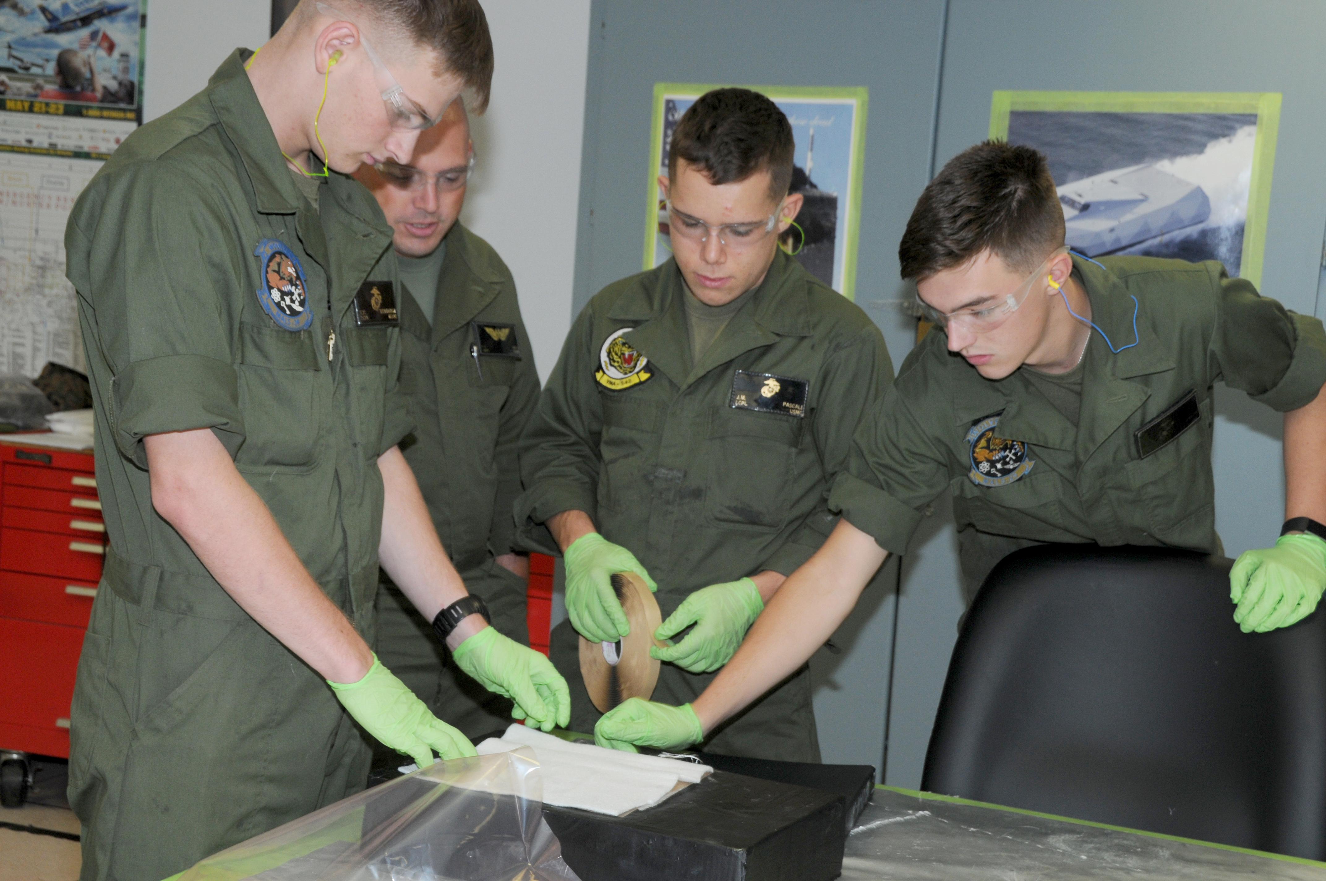 Marines work together to practice composite repair skills learned during course