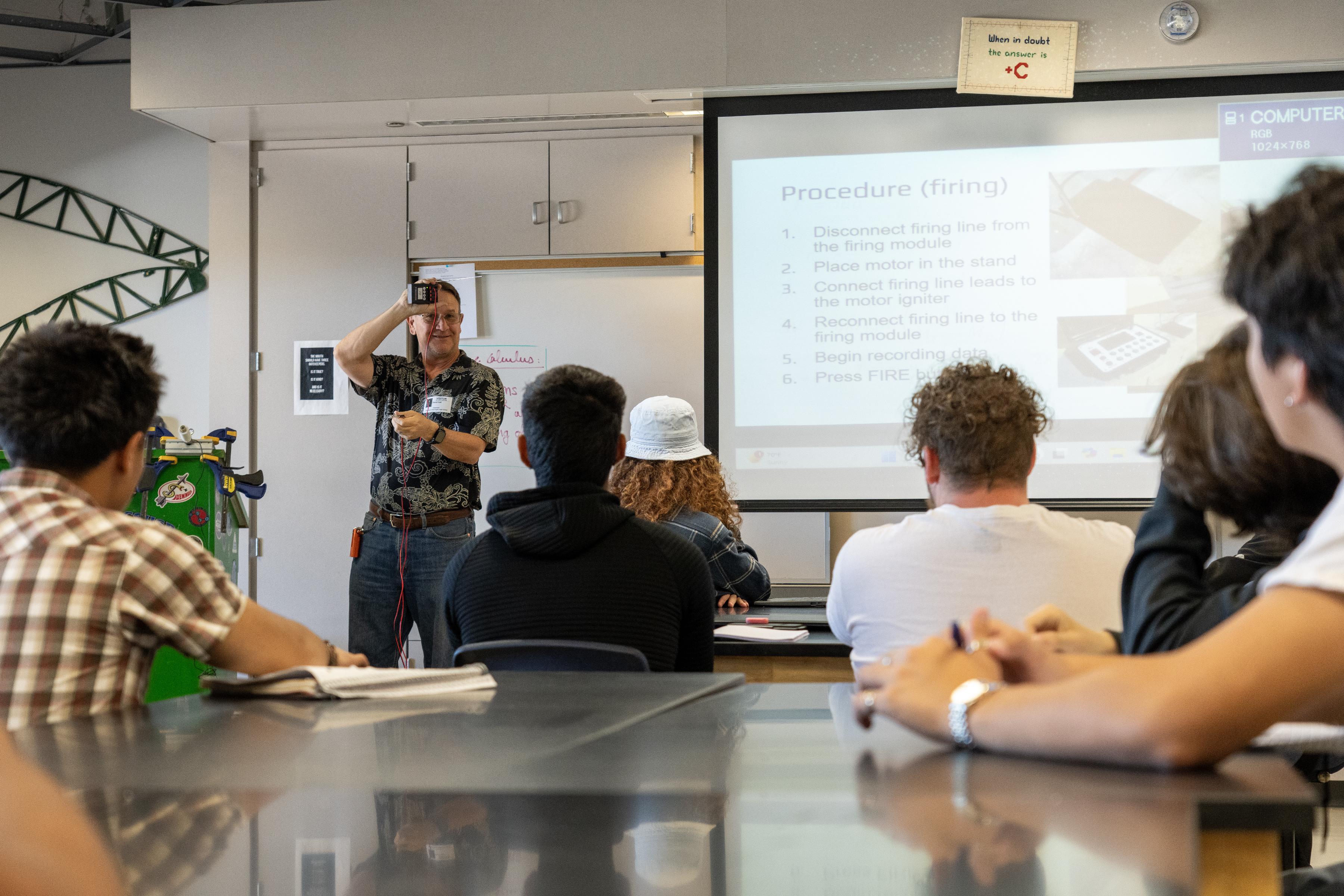 Naval Air Warfare Center Weapons Division Chief Engineer for the Ordnance Test and Evaluation Division David Hall teaches students at Burroughs High School the principles of rocketry in preparation for the annual rocket launch May 29 in Ridgecrest, Calif. (U.S. Navy photo by Ryan Smith)