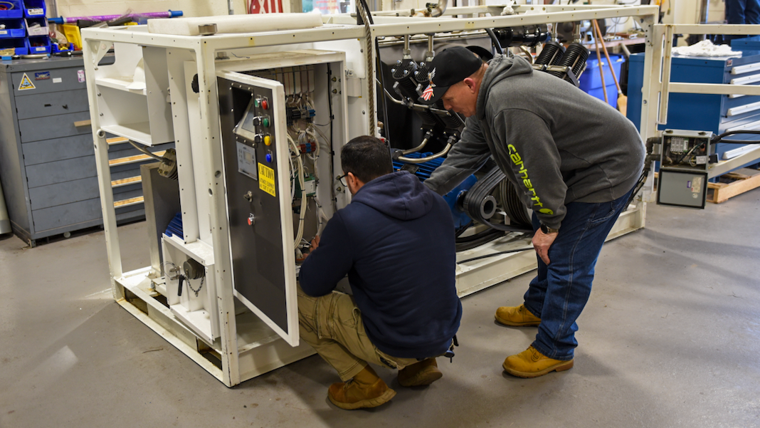 Team members work on a piece of cryogenic equipment at NAWCAD Lakehurst