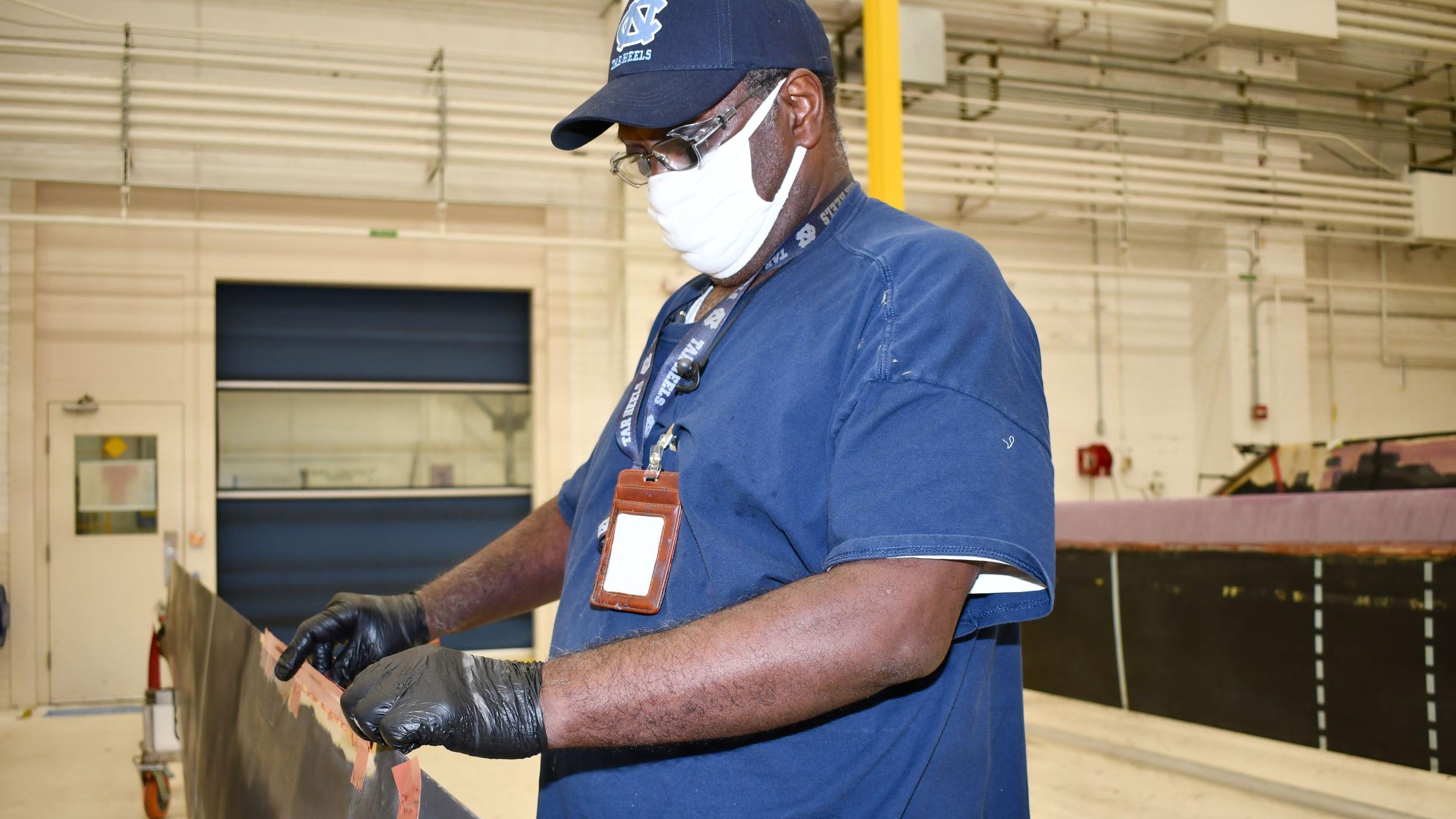 Man repairs H-53 helicopter main rotor blade
