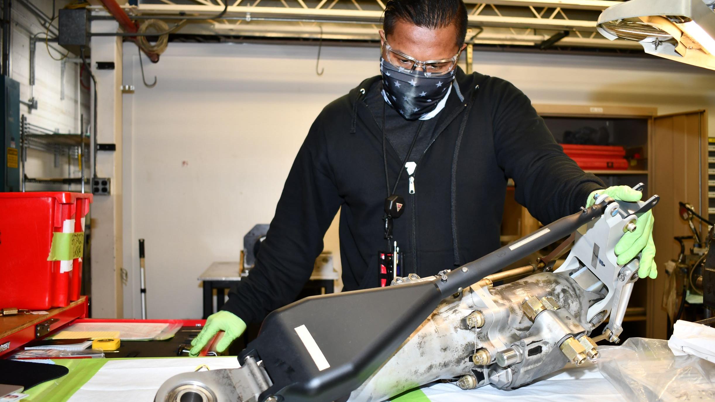Man assembles H-53 helicopter primary servo cylinder