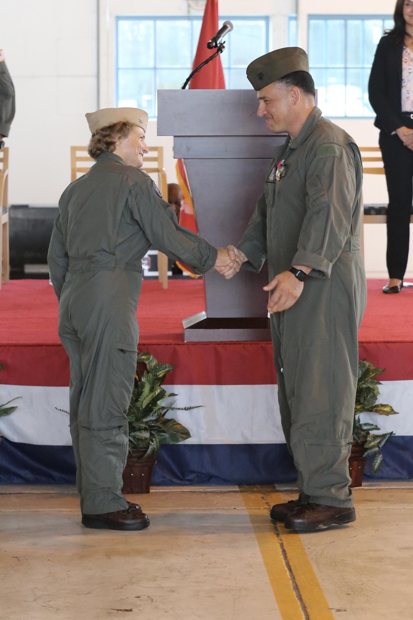 Capt. Elizabeth Somerville shakes hands with Col. Richard Marigliano in front of the podium during a change of command ceremony.