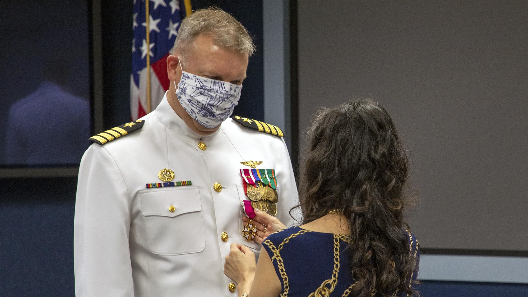 Capt. A.J. McFarland watches as his wife Clarisa pins him with the Legion of Merit during a change of command ceremony June 19 in Point Mugu, California. (U.S. Navy photo by Brian Wulfekotte)