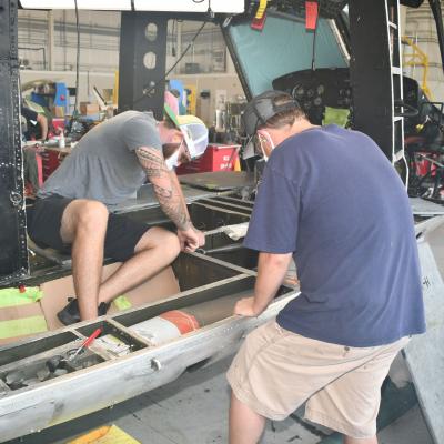Men work on H-1 helicopter