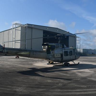 UH-1N "Huey" sits in front of aircraft hangar