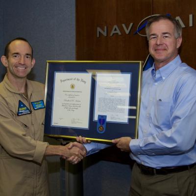 Brad Harlow accepts a Navy Meritorious Civilian Service Award from Rear Adm. Scott Dillon, NAWCWD commander, during a ceremony Aug. 29 at China Lake. (U.S. Navy photo by Paul Kakert)