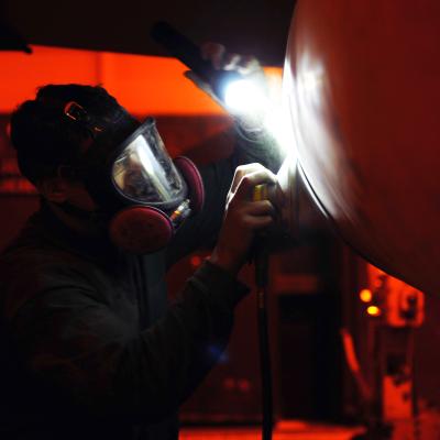 U.S. Navy Seaman performs corrosion prevention maintenance on an F/A-18F Super Hornet 
