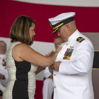 Cmdr. Paul Meyer receives his command pin from his wife