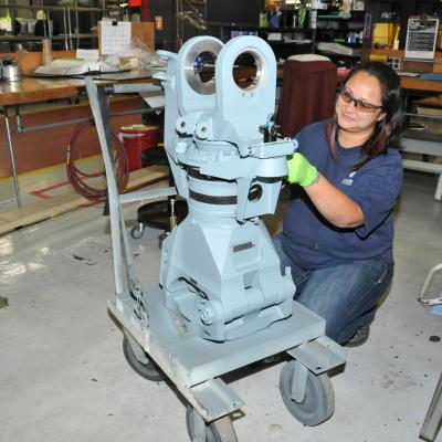 Aircraft mechanical parts repairer inspects a sleeve and spindle for an H-53 helicopter rotor head