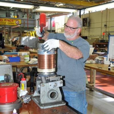 Aircraft mechanic works on a bearing stack-up for an H-53 helicopter rotor head