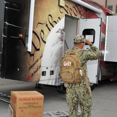 Sailor prepares to move box containing donate blood.