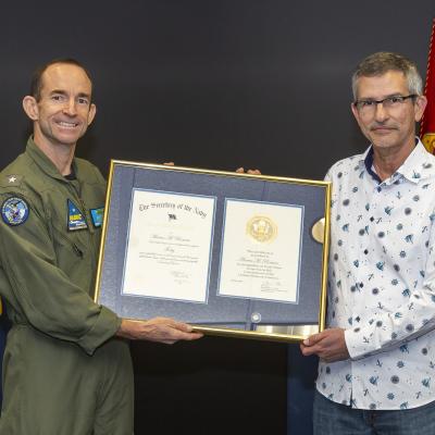 Rear Adm. Scott Dillon presents a 40-year length-of-service award to Marc Romero