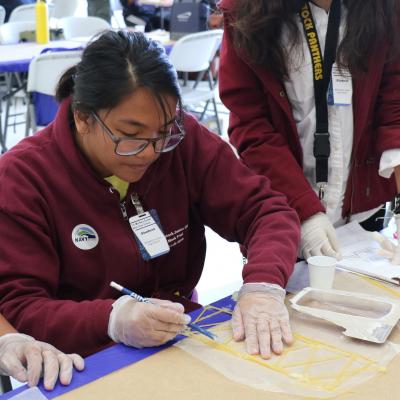 Students from Blackstock Junior High work on their spaghetti bridges during the annual Tri-Warfare Center STEM Challenge in Point Mugu, California, on Feb. 20. (U.S. Navy photo by Kimberly Brown)