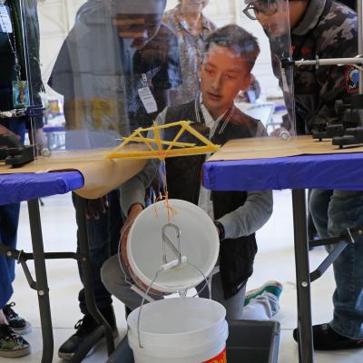 Students test their bridge during the annual Tri-Warfare Center STEM Challenge in Point Mugu, California, on Feb. 20. (U.S. Navy photo by Kimberly Brown)