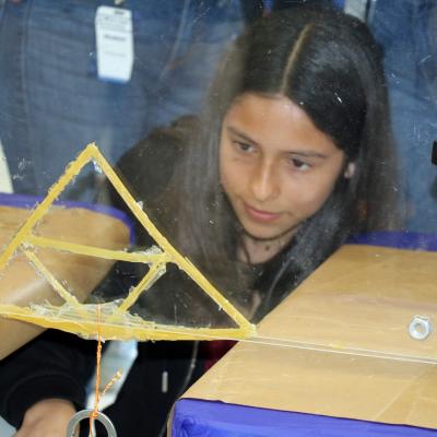 A student from Cesar Chavez Middle School tests their bridge during the annual Tri-Warfare Center STEM Challenge in Point Mugu, California, on Feb. 20. (U.S. Navy photo by Kimberly Brown)