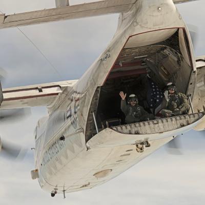 Long-time C-2A aircrew Jim Fortini, left, and Al Griffin wave from the back of C-2A Greyhound BuNo 162142 on its last flight, which took place last month. The aircraft, which has been flying with VX-20 for nearly 30 years, will be retired to the Patuxent River Naval Air Museum. (U.S. Navy photo by Erik Hildebrandt)