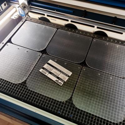 A batch of acrylic face shields made by Lt. Gavin “Flanders” Kurey and his wife Katie, using the industrial laser cutter at their metalworking shop, are ready for assembly with 3D printed headbands for donation to local hospitals and medical clinics. (U.S. Navy photo by Lt. Gavin Kurey)