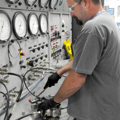 Man prepares to check F-35 valve on test stand