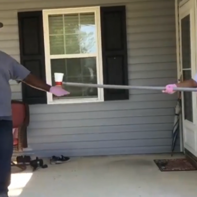 Girl passes a drink to an adult using a tool she invented during educational challenge
