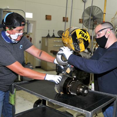 FRCE artisans use crane to lift H-53 nose gearbox assembly.