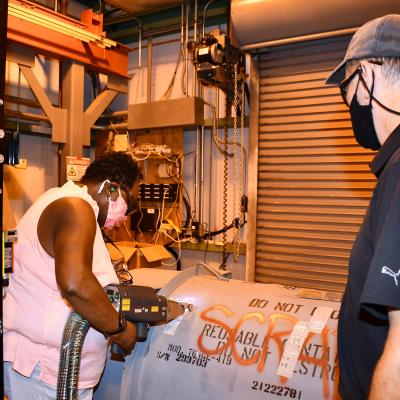 Worker uses laser while trainer watches