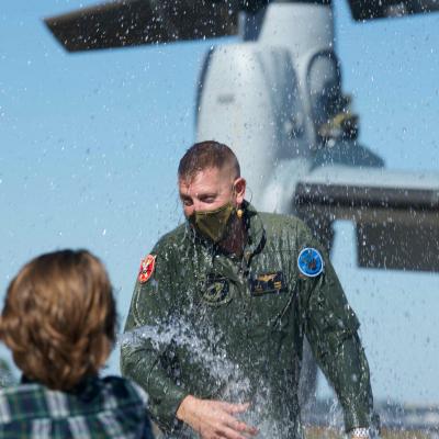 Lt. Col. John Ennis reacts to being doused by his son following a ceremonial airborne passing of the command on Oct. 9, 2020, part of the change of command ceremony for Air Test and Evaluation Squadron (HX) 21 during which Ennis was relieved by Cmdr. Daniel Short, the squadron’s chief test pilot. (U.S. Navy photo by Paul Lagasse)