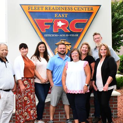 Group poses for photo in front of FRC East sign