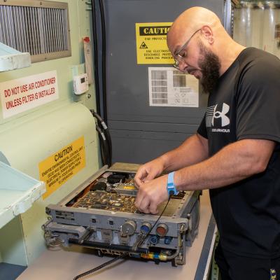 Civilian electronics integrated system mechanic works with a radar transmitter from an F/A-18 Hornet.