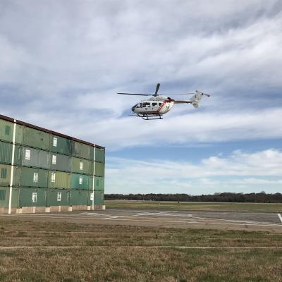 A U.S. Naval Test Pilot School (USNTPS) UH-72A Lakota hovers near the Elevated Fixed Platform as part of a test program developed by USNTPS rotary wing instructors John Tritschler and John Holder to evaluate the hover performance of helicopters near obstacles and inside confined areas.