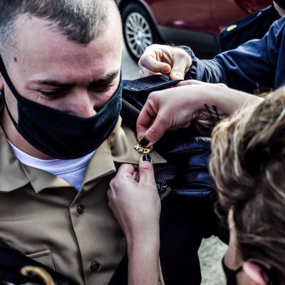 Chief Aviation Electronics Technician Joshua Coughlin receives his anchors from family members during a chief petty officer (CPO) pinning ceremony hosted by the U.S. Naval Test Pilot School at Naval Air Station Patuxent River on Jan. 29, 2021.