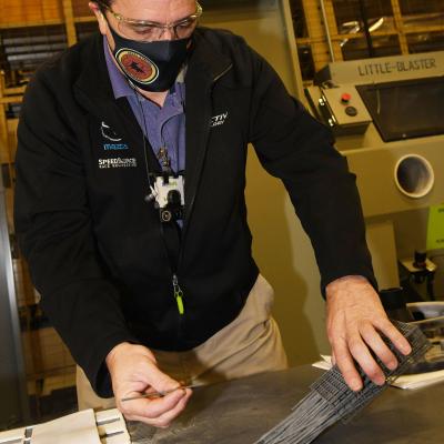 Fleet Readiness Center Southeast (FRCSE) Tool Designer Randy Meeker opens a nasopharyngeal swab cage. 
