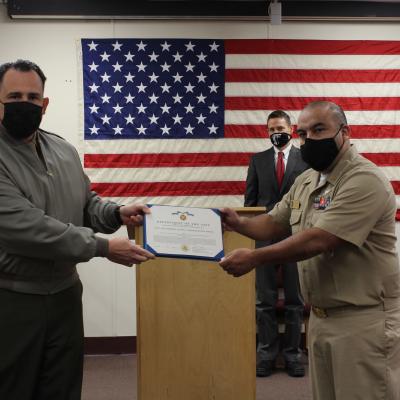Col. Richard E. Marigliano, commander of Naval Test Wing Atlantic (NTWL), left, presents Chief Aviation Electrician’s Mate (Aviation Warfare) Sergio Reyes of Air Test and Evaluation Squadron (HX) 21 with NTWL's Maintenance Chief Petty Officer of the Year award for 2020 during a ceremony on February 12 2021.