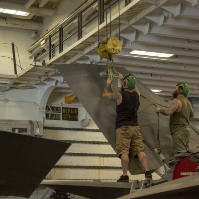 Two aircraft mechanics perform repairs on F-35B