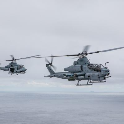 A UH-1Y Venom and AH-1Z Viper fly alongside the Wasp-class amphibious assault ship USS Iwo Jima (LHD 7) during a photo exercise, May 17, 2021. 