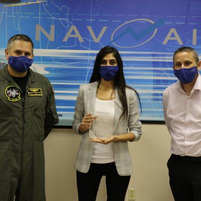 Manik Yeremyan, center, holds her Test Engineer of the Year Award, presented to her by Cmdr. Jason Saglimbene, VX-30 commanding officer, and Dan Toland, Weapons and Warfare Systems Test Department head, in a ceremony Oct. 7 in Point Mugu. (U.S. Navy photo by Kimberly Brown)