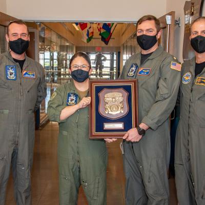 A team from the U.S. Naval Test Pilot School is pictured with an award plaque. 