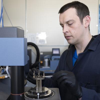 Michael Garrison, NAWCWD research chemist, loads a polymer sample for dynamic mechanical analysis. The technique allows researchers to measure the mechanical properties of polymers at different temperatures. (U.S. Navy photo by Scott Clarke)