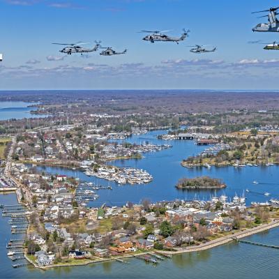 Rotary aircraft fly in a V formation over the Patuxent River and Solomons Island, Maryland.