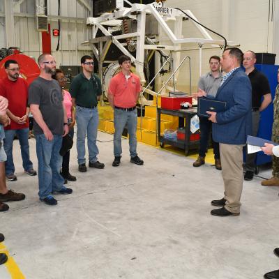 Col. Mark R. Amspacher, second from right, AV-8B Weapon Systems Program Office (PMA-257) manager, delivers remarks to FRCE staff prior to presenting letters of appreciation Mar. 31. PMA-257 recognized FRCE for its outstanding support of the AV-8B Propulsion Integrated Product Team and the AV-8B Harrier fleet.