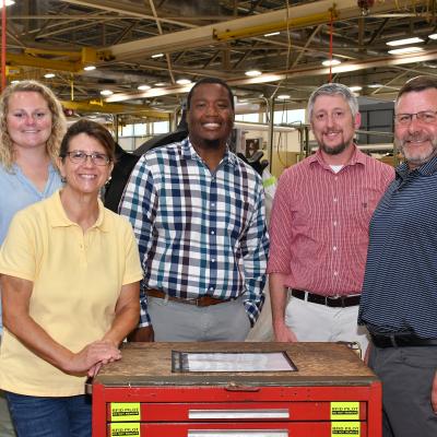 Members of the Fleet Readiness Center East (FRCE) digital tracking team pose for a group photo with a toolbox fitted with radio frequency identification (RFID) technology tags. The digital tracking team, composed of a wide range of subject matter experts from within the depot’s workforce, recently demonstrated a successful proof of concept for a digital tracking system incorporating RFID and other technology. FRCE officials say the system could boost efficiency and accountability within the FRCE workforce.