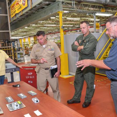 Jarred Burr, right, an electrical engineering technician at Fleet Readiness Center East (FRCE), briefs FRCE Commanding Officer Capt. James Belmont on radio frequency identification (RFID) technology tags tested and evaluated at the depot. FRCE recently demonstrated a successful proof of concept for a digital tracking system incorporating RFID and other technology. Depot officials say the system could boost efficiency and accountability within the depot’s workforce. 