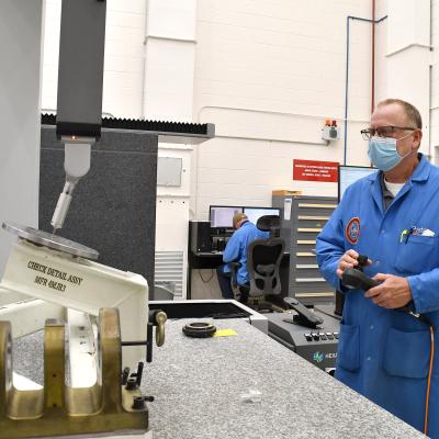 Ben Pate, operations manager at Fleet Readiness Center East’s (FRCE) Precision Measurement Center, operates a coordinate measuring machine (CMM). A CMM is a device that measures the geometry of physical objects by sensing points on the surface of the object with a probe. 